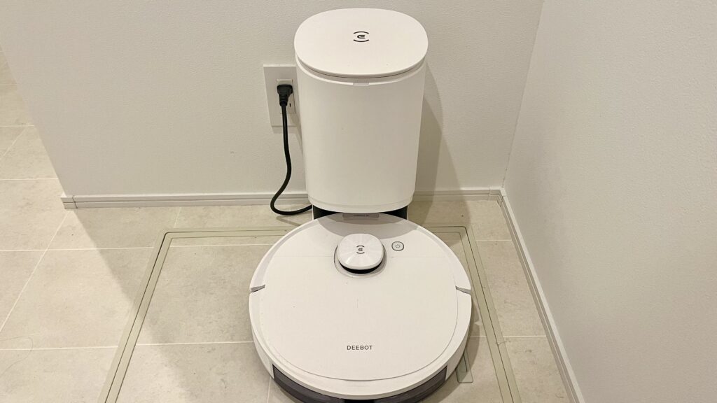 自動ゴミ収集ドックにセットされたECOVACSのロボット掃除機DEEBOT N8pro+。白い本体が壁際に設置されており、省スペースでスッキリ置ける様子が分かる