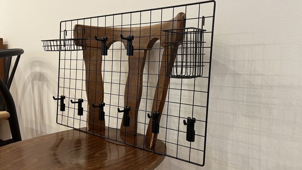 ダイソーのワイヤーネットにフックやカゴを取り付けた仮組みの状態。椅子に立てかけた設置イメージ