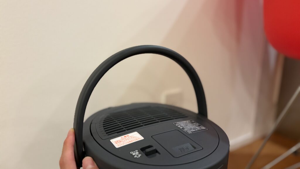 象印EE-TB60の取っ手部分を持ち上げている様子。軽くて持ち運びがしやすい設計