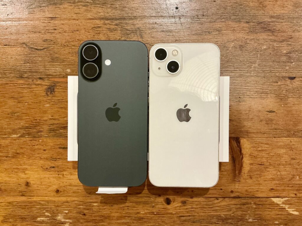 iPhone17ブラックとiPhone13ホワイトの背面デザイン比較。カメラ配置や質感の違いが分かる写真。