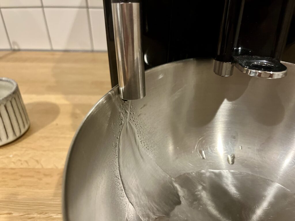 スチームノズルから排出される除石灰液を受け容器で受けている様子