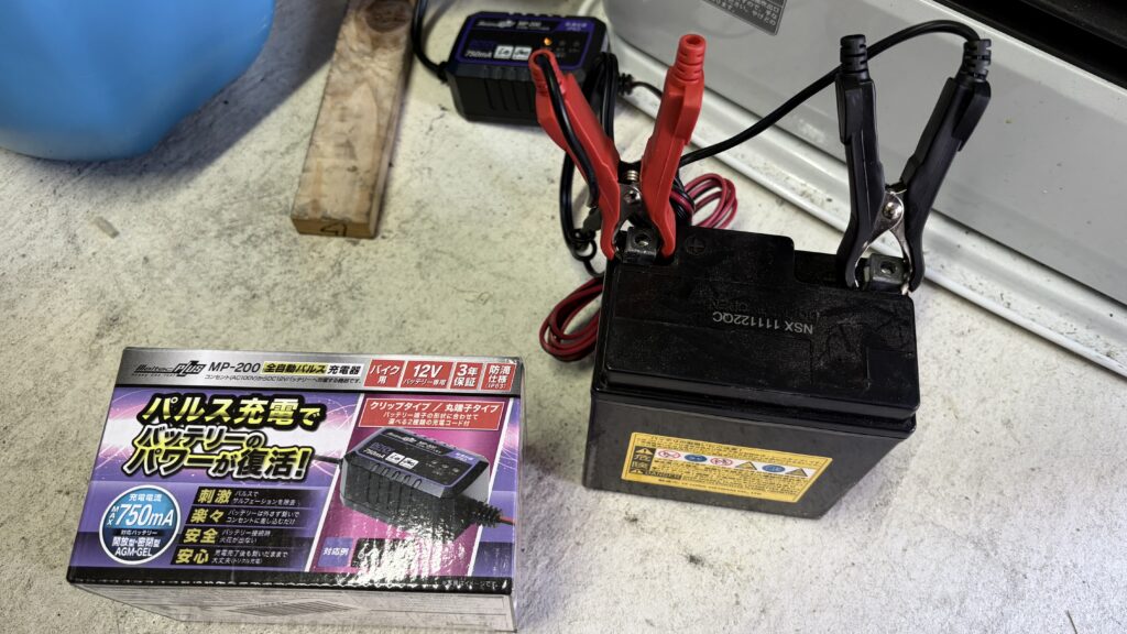 バイク用バッテリーにパルス充電器を接続して充電している様子